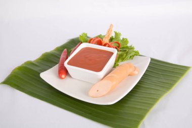 Aperatif dilimlenmiş sosis ve biber sosu.