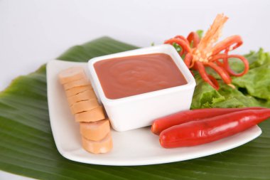 Aperatif dilimlenmiş sosis ve biber sosu.