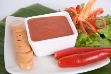 Aperatif dilimlenmiş sosis ve biber sosu.