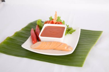 Aperatif dilimlenmiş sosis ve biber sosu.