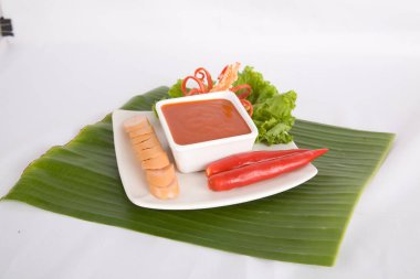 Aperatif dilimlenmiş sosis ve biber sosu.