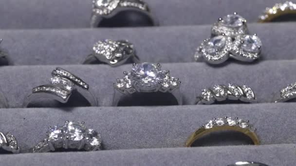 ( 영어 ) Close-Up Shot Of A Ring With A Diamond In Jewelry Shop Display. 보석과 카메라가 있는 많은 약혼 반지들이 다이아몬드와 함께 반지로 확대되고 있습니다. — 비디오