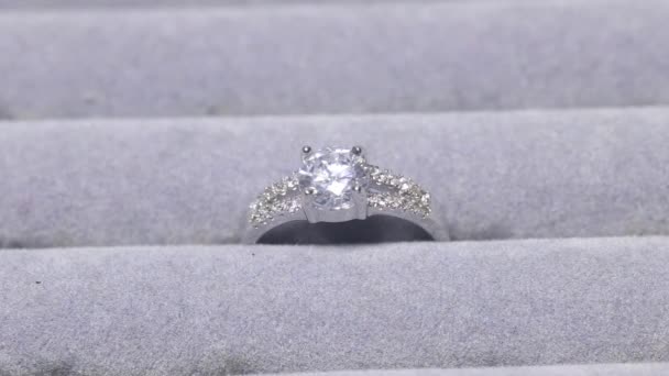Tiro de perto de um anel com um diamante na exposição da loja de jóias. Muitos anéis de noivado com pedras preciosas e câmera está ampliando para o anel com o diamante. — Vídeo de Stock