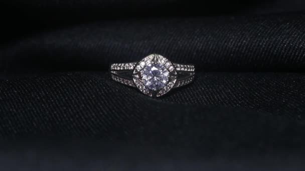 ダイヤモンドリングの極端な詳細は、暗い背景に撮影を閉じます。結婚指輪は、被写界深度の浅いマクロレンズで撮影。婚約、結婚、結婚式のコンセプト — ストック動画