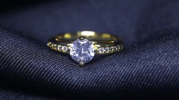 Golden wedding ring on black background. Jewelry with diamonds — Stock Video