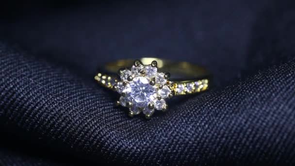 Anillo de boda dorado sobre fondo negro. Joyería con diamantes — Vídeos de Stock