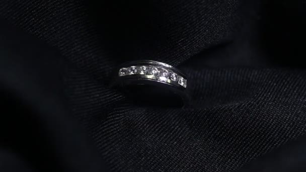 Extrém részletességgel gyémánt gyűrű közelről lövés sötét háttérrel. A jegygyűrűt makró lencsével lőtték le, sekély mélységű mezővel. Eljegyzés, házasság és esküvő koncepció — Stock videók