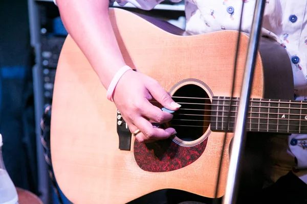 黒い木製のアコースティックギターで音楽を演奏する男指に焦点を当てる — ストック写真