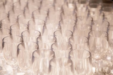 Arka arkaya bir sürü şarap kadehi. Barmen tarafından şampanya ve şarap için hazırlanmış bir masanın üzerinde duran boş temiz bardaklar. Bir rafta saydam bardaklar. Etkinlik için yemek servisi.