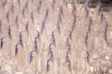 Arka arkaya bir sürü şarap kadehi. Barmen tarafından şampanya ve şarap için hazırlanmış bir masanın üzerinde duran boş temiz bardaklar. Bir rafta saydam bardaklar. Etkinlik için yemek servisi.