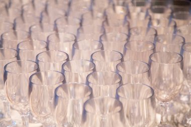 Arka arkaya bir sürü şarap kadehi. Barmen tarafından şampanya ve şarap için hazırlanmış bir masanın üzerinde duran boş temiz bardaklar. Bir rafta saydam bardaklar. Etkinlik için yemek servisi.