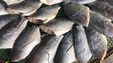 Kurutulmuş balık kurutma bitkisi olan gourami balığı. Yerel pazarda hasır masada kurutulan tuzlu koruma deniz ürünleri çiğ balık filetoları..
