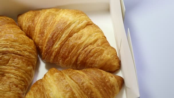 Croissant encontra-se em um fundo branco. produtos de padaria em fundo isolado — Vídeo de Stock