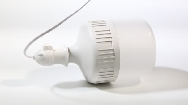 Lâmpada LED de poupança de energia e eco-friendly sobre um fundo branco. Fechar. — Vídeo de Stock