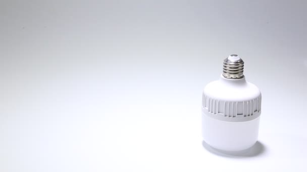 Energiaa säästävä, ympäristöystävällinen led-lamppu valkoisella taustalla. lähikuva-analyysi — kuvapankkivideo