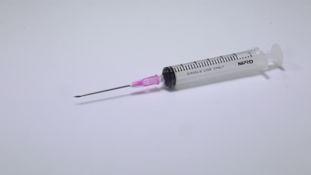 Medical syringe. Disposable and reusable medical syringe rotates on white table. Syringes in a package. Healthcare and medical concept. — Stock Video