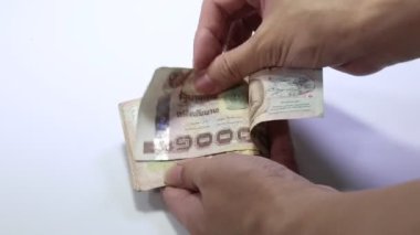 Tayland bahtını sayan kişi. Bin banknot..