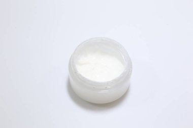 Beyaz arka planda beyaz bir güzellik kremi var.