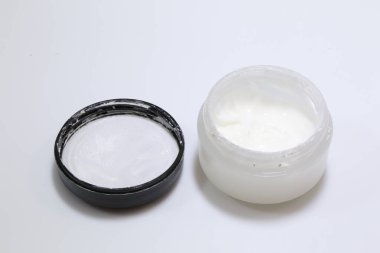 Beyaz arka planda beyaz bir güzellik kremi var.