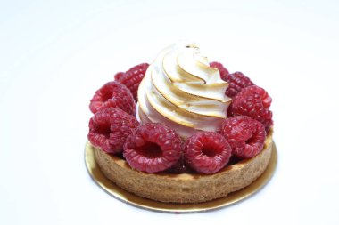 Beyaz tabakta ahududulu kremalı turta. Bizetli turta ve taze böğürtlen..