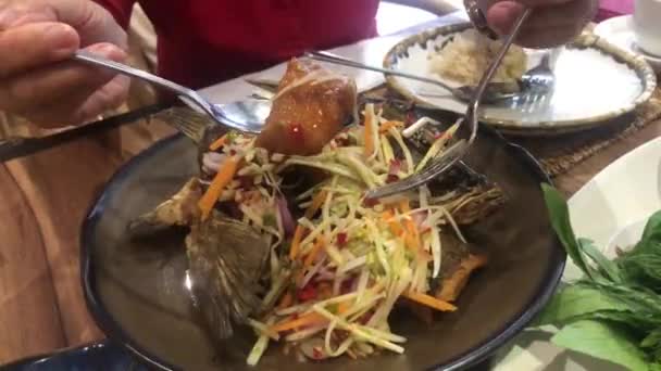 Basso marino fritto con salsa di pesce dolce mangiare con insalata di mango spezia su sfondo di legno — Video Stock