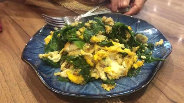 タイ南部の伝統的な料理スタイルの卵やジェントム グネモンやマリンジョーと炒めバゲウの葉 — ストック動画