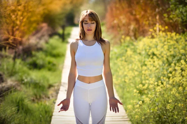 Doğada Yoga Yaparken Genç Kadın Beyaz Spor Kıyafetlerle Ahşap Bir — Stok fotoğraf
