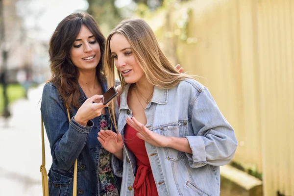 Två Unga Kvinnor Spelar Ett Röstmeddelande Med Smarta Telefonen Utomhus — Stockfoto
