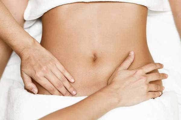 俯瞰双手按摩女性腹部 治疗师对腹部加压 在温泉沙龙接受按摩的妇女 — 图库照片