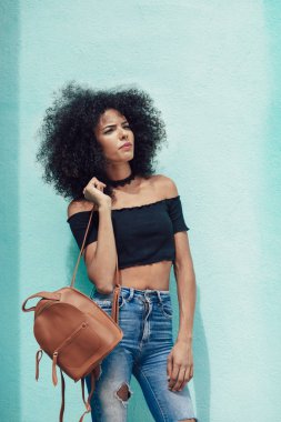 Genç afro saç ayakta sokakta kadın karışık. Kadın kentsel arka planda rahat kıyafetler giyiyor. Yaşam tarzı kavramı