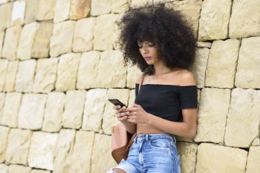 Afro saçlı onun akıllı telefon açık havada arıyorum ciddi siyah kadın. Yaşam tarzı kavramı
