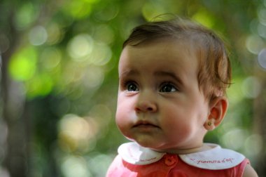 Yakın çekim bir şey de açık havada ufuk arka plan ile seyir altı aylık bebek kız portresi.