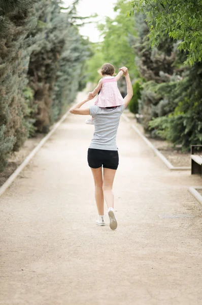 Menina Andando Sobre Ombros Sua Mãe Parque — Fotografia de Stock
