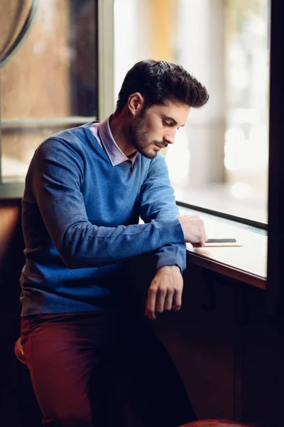 Hombre Joven Con Suéter Azul Mirando Teléfono Inteligente Pub Moderno — Foto de Stock