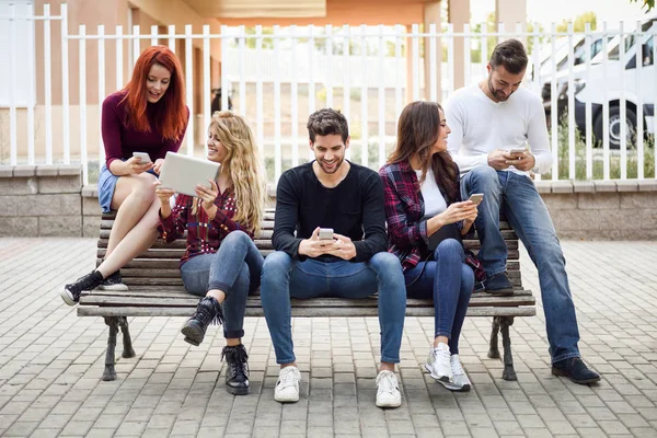 Grupo Jóvenes Que Utilizan Teléfonos Inteligentes Tabletas Aire Libre Fondo — Foto de Stock