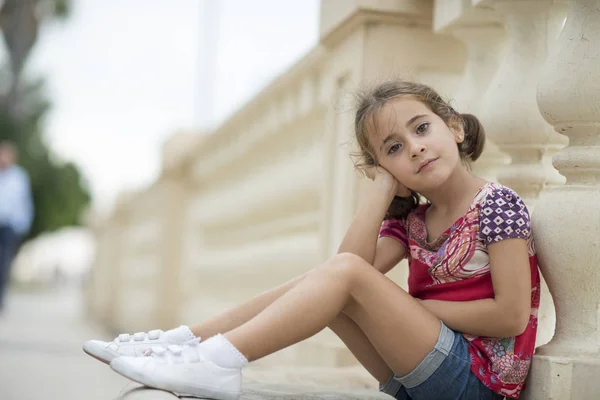 Adorável Menina Penteada Com Tranças Livre Sentado Chão Urbano — Fotografia de Stock