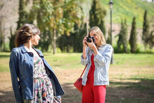 两名年轻的旅游妇女在城市公园模拟反射相机拍照 旅行者概念 — 图库照片