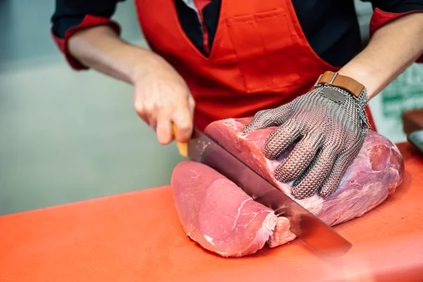 女性肉屋金属安全と精肉店で新鮮な肉を切るメッシュ グローブ — ストック写真