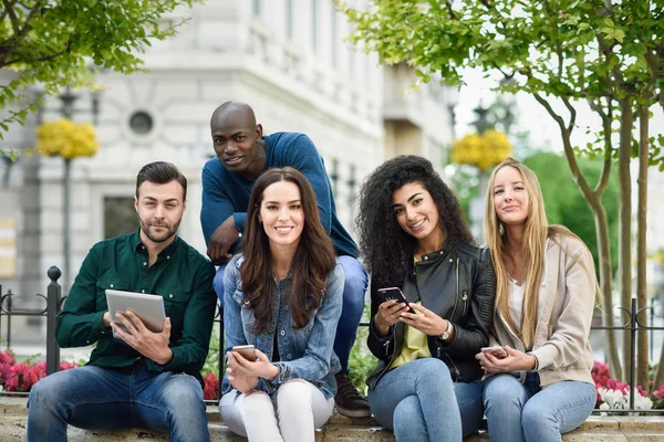 Grupo Multiétnico Jóvenes Que Utilizan Teléfonos Inteligentes Tabletas Aire Libre — Foto de Stock