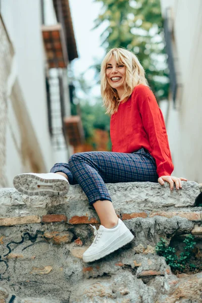 Glückliche Junge Blonde Frau Sitzt Auf Städtischem Hintergrund Lächelndes Blondes — Stockfoto