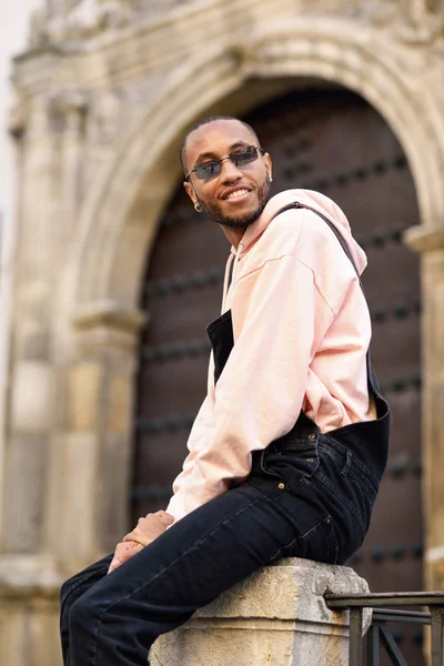 Joven Hombre Negro Con Ropa Casual Gafas Sol Sentado Fondo —  Fotos de Stock