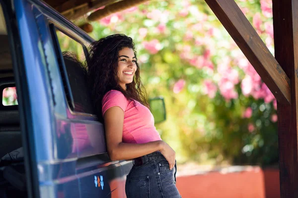 Молода жінка у фургоні в прекрасному кемпінгу з рожевими квітами — стокове фото