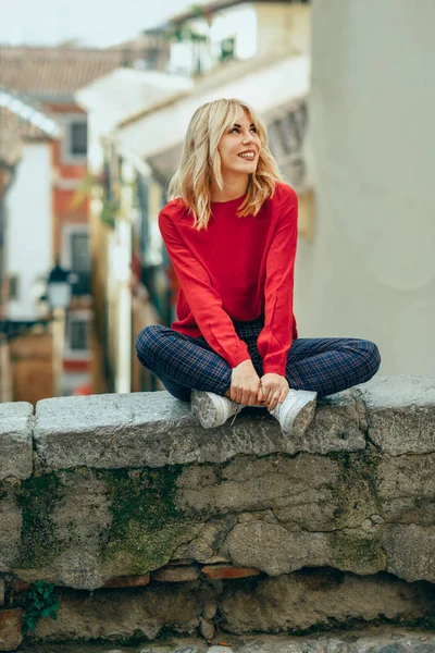 Sorrindo menina loira com camisa vermelha apreciando a vida ao ar livre . — Fotografia de Stock