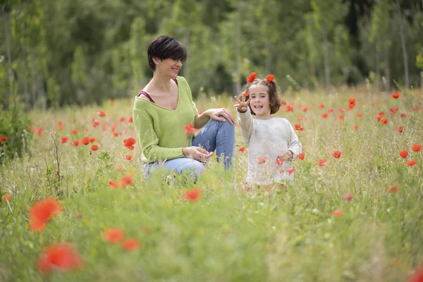 Мать со своей маленькой дочерью на маковом поле — стоковое фото