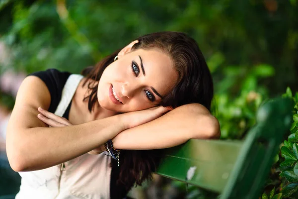 Szczęśliwa Młoda Kobieta Niebieskich Oczach Patrząc Kamery Siedząc Ławce Miejskich — Zdjęcie stockowe
