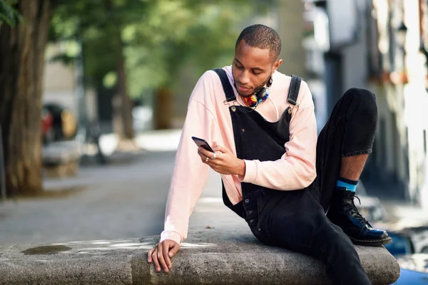 Giovane uomo nero utilizzando smart phone all'aperto — Foto Stock