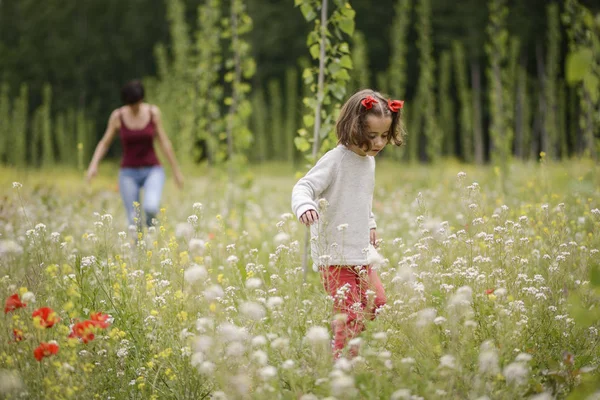 Mãe com sua filhinha no campo de papoula — Fotografia de Stock