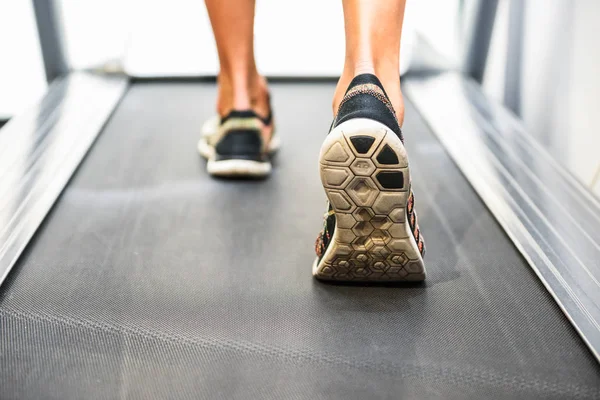 Мужские мускулистые ноги в кроссовках бегают по беговой дорожке в спортзале . — стоковое фото