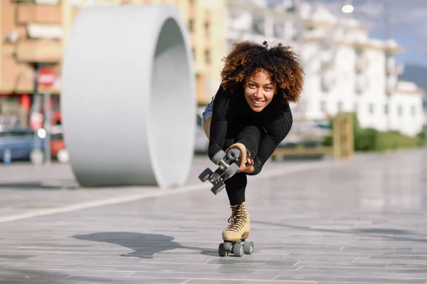 Mujer negra en patines de ruedas montando al aire libre en la calle urbana — Foto de Stock