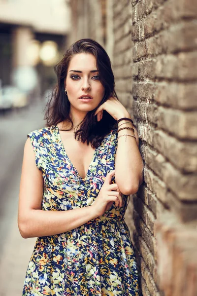 Fille avec les yeux bleus debout à côté du mur de briques à l'extérieur — Photo